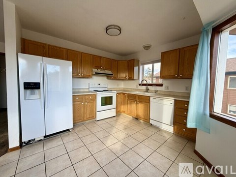 A kitchen with white appliances and wooden cabinets.