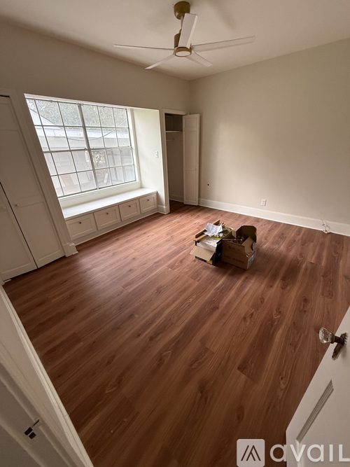 A room with wooden floors and a ceiling fan.
