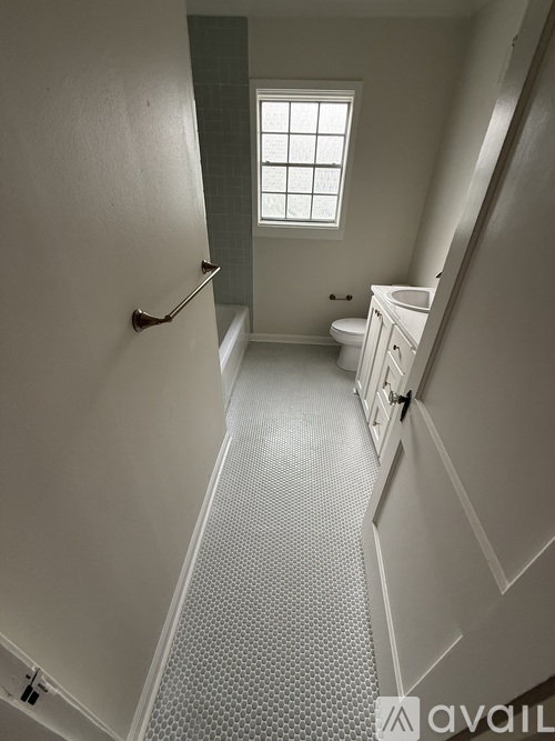 A bathroom with a toilet, sink, and window.