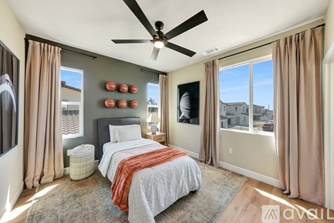 A bedroom with a bed, a ceiling fan, and a window with curtains.