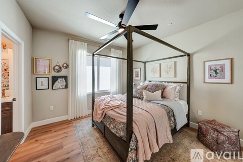 A bedroom with a four poster bed and a ceiling fan.