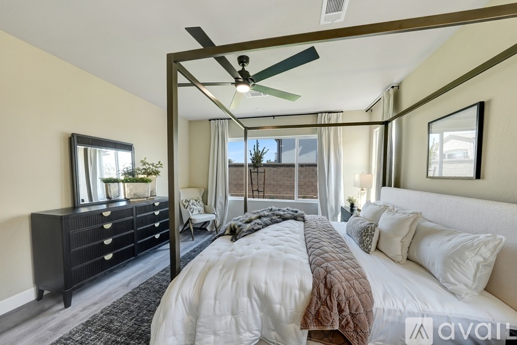 A bedroom with a large bed and a ceiling fan.