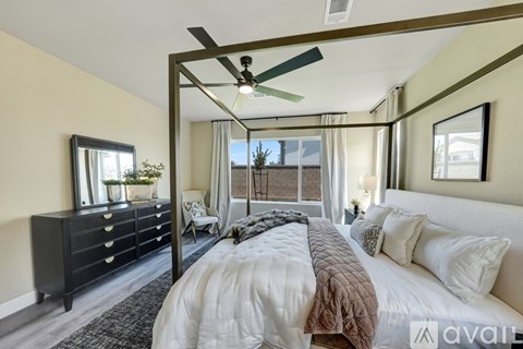 A bedroom with a large bed and a ceiling fan.