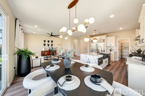 A modern dining room with a black table set for four.