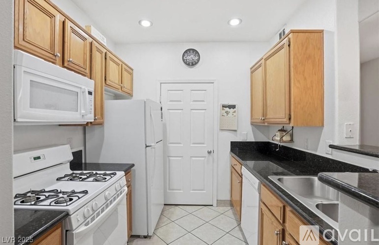 A kitchen with white appliances and wooden cabinets.
