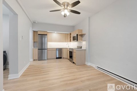 A kitchen area with wooden floors and a ceiling fan.