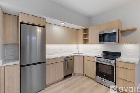 A kitchen with wooden cabinets and a stainless steel refrigerator.