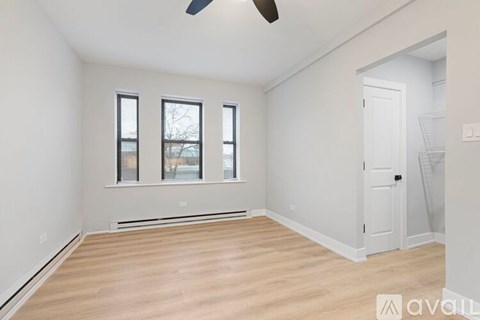 A room with a white ceiling, a fan, and a door.