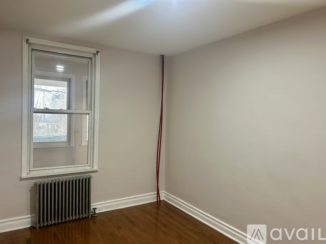 A room with a window and a radiator on the floor.