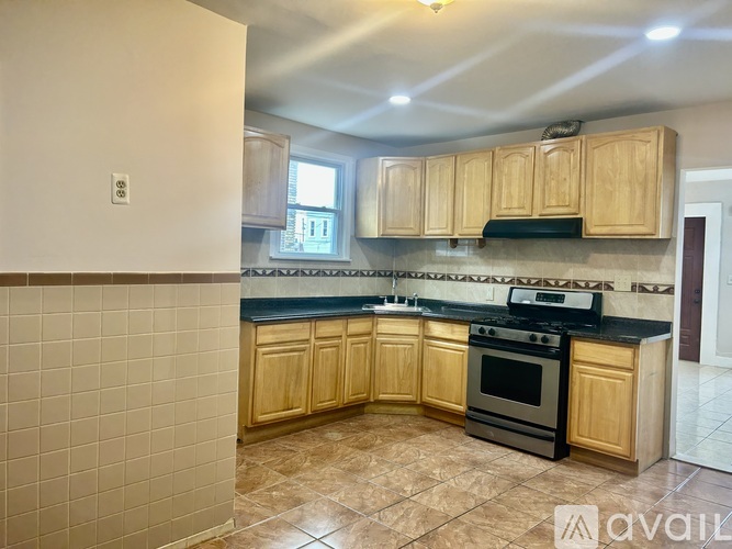 A kitchen with wooden cabinets and a black stove top oven.