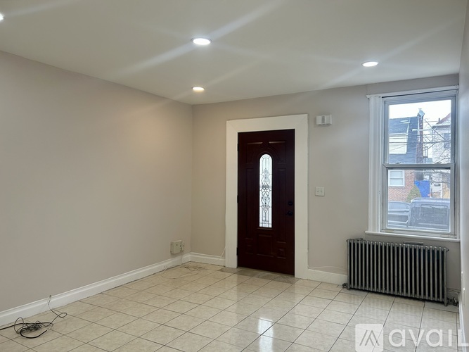 A room with a door, window, and radiator.