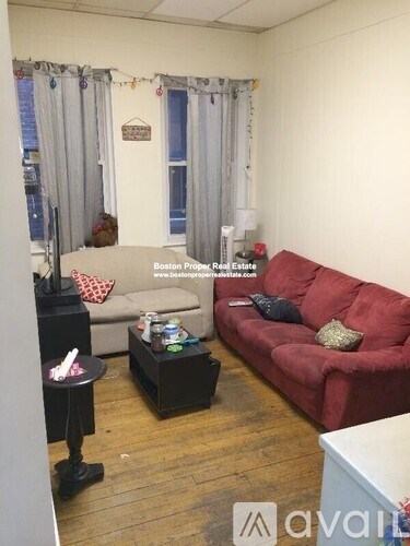 A living room with a red couch and a black coffee table.