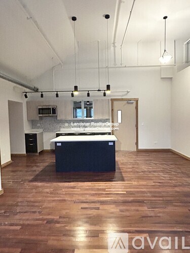 A large open space with a kitchenette and a long table.