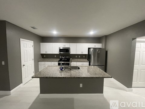 A kitchen with granite countertops and stainless steel appliances.