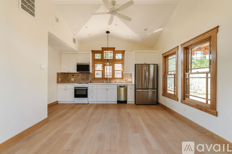 A white ceiling fan in a room with wooden cabinets.