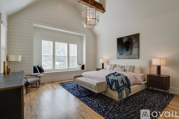 A bedroom with a large bed and a painting on the wall.