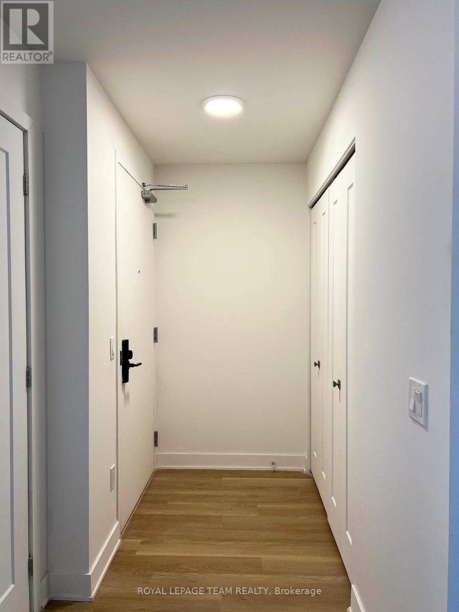 A long, narrow hallway with white walls and wood flooring.