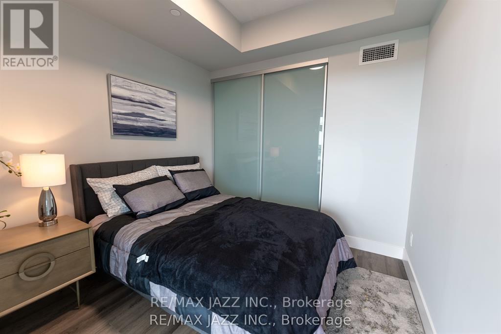 A bedroom with a bed, nightstand, and lamp.
