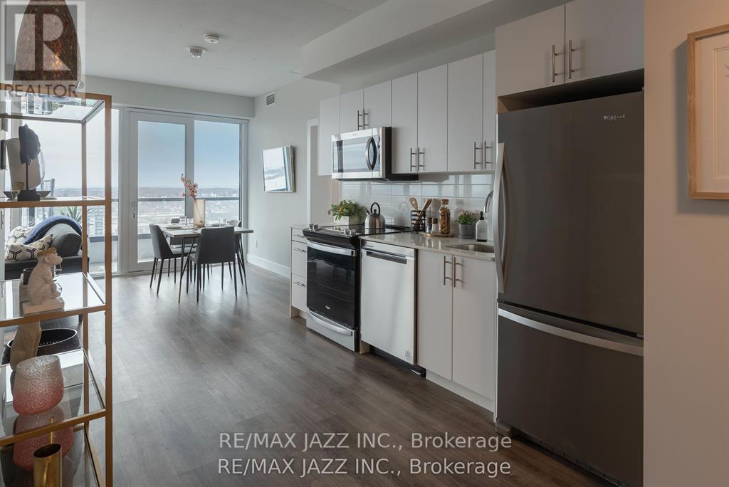 A modern kitchen with white cabinets and stainless steel appliances.