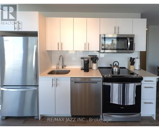 A kitchen with white cabinets and a stainless steel refrigerator.
