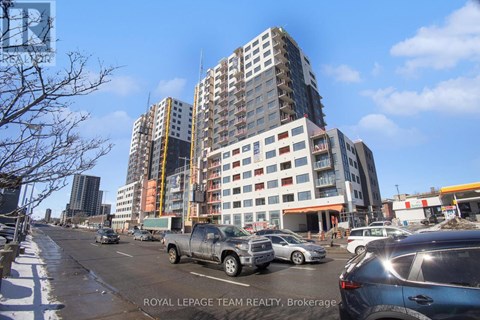 A city street with cars and a large building under construction.