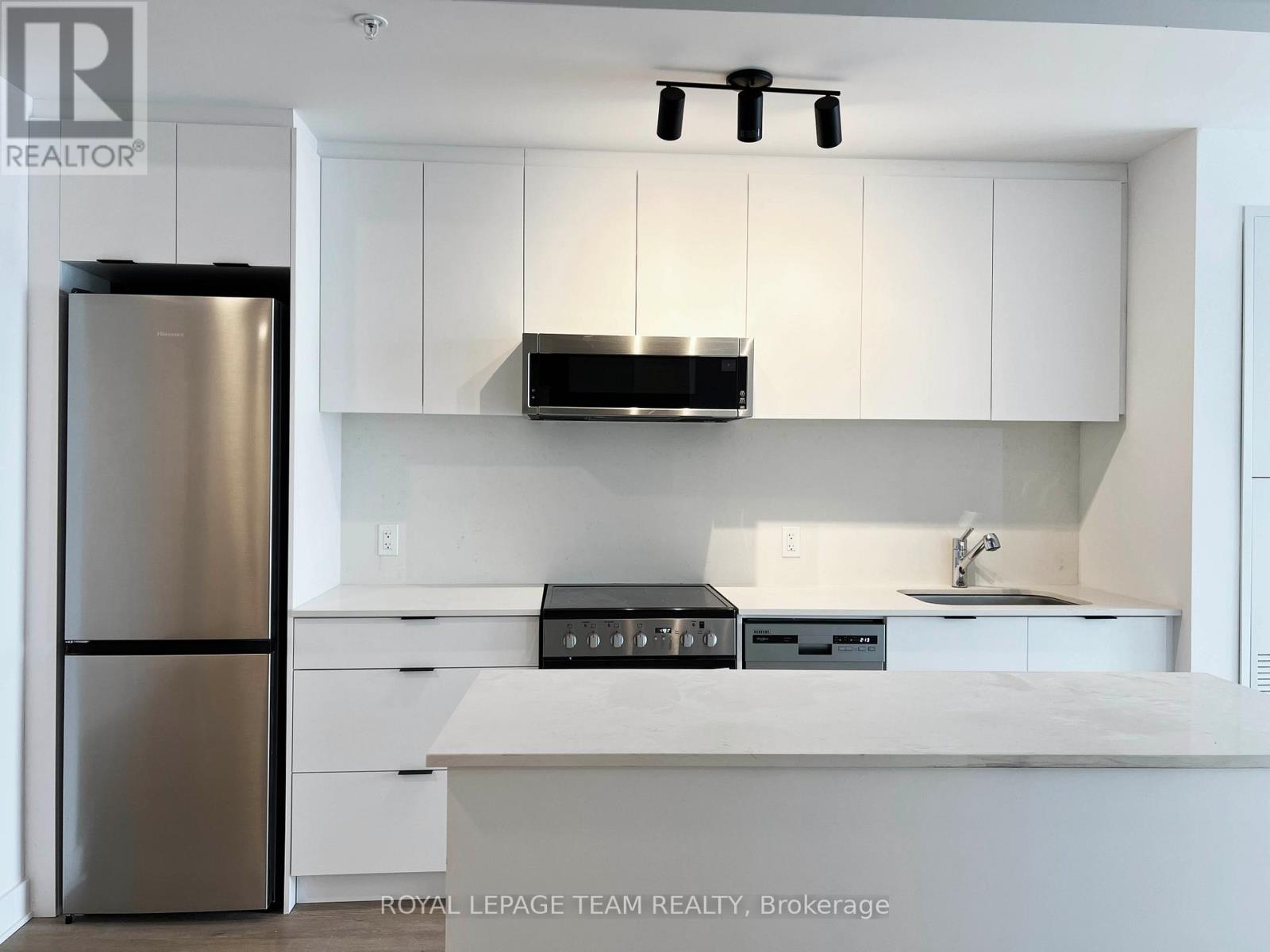A modern kitchen with white cabinets and stainless steel appliances.