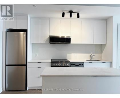 A modern kitchen with white cabinets and stainless steel appliances.