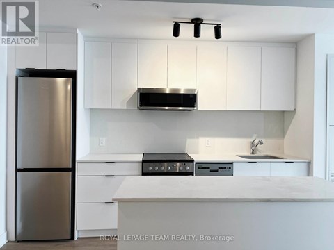A modern kitchen with white cabinets and stainless steel appliances.