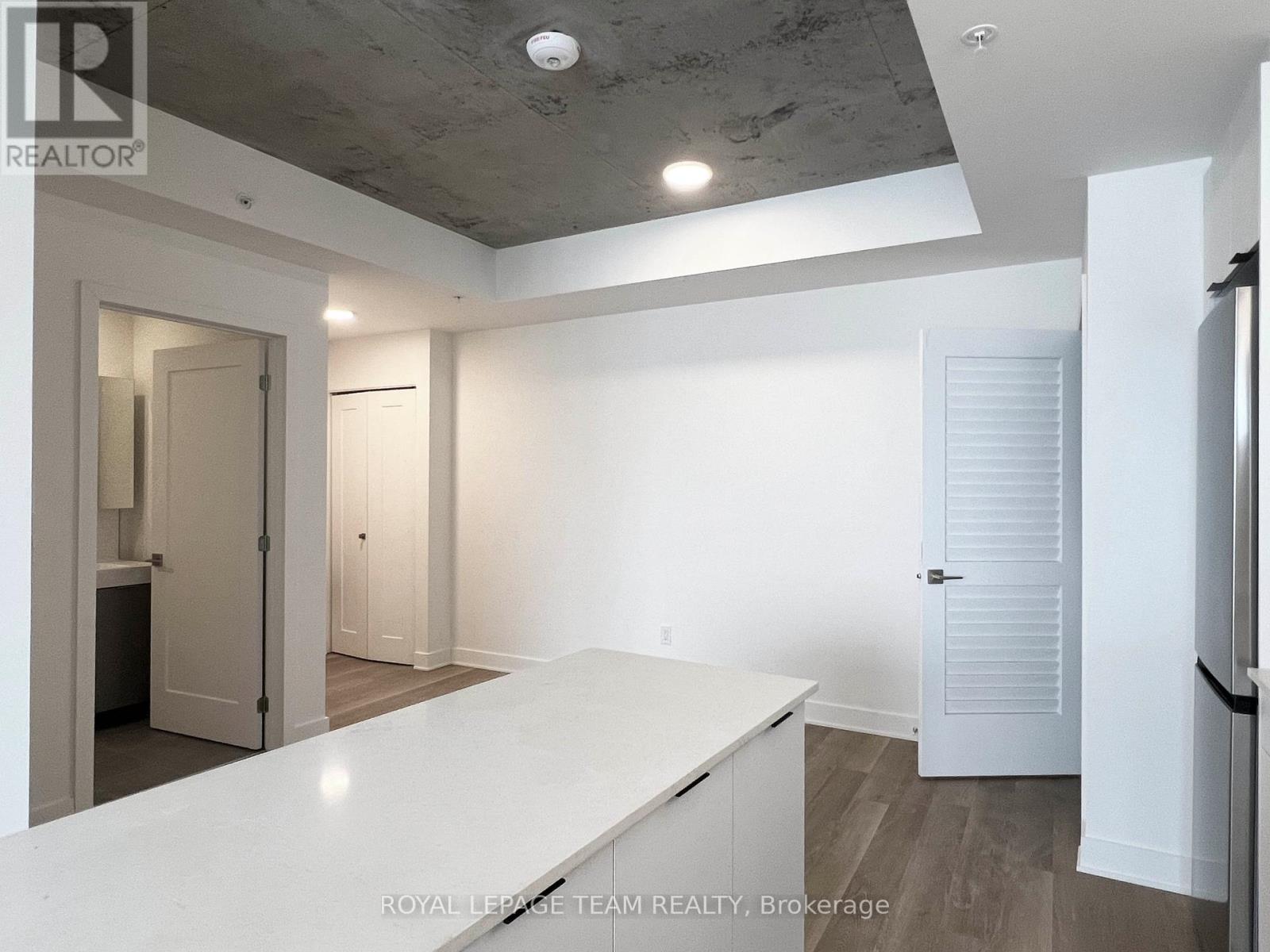 A spacious room with a white countertop and a ceiling with exposed beams.