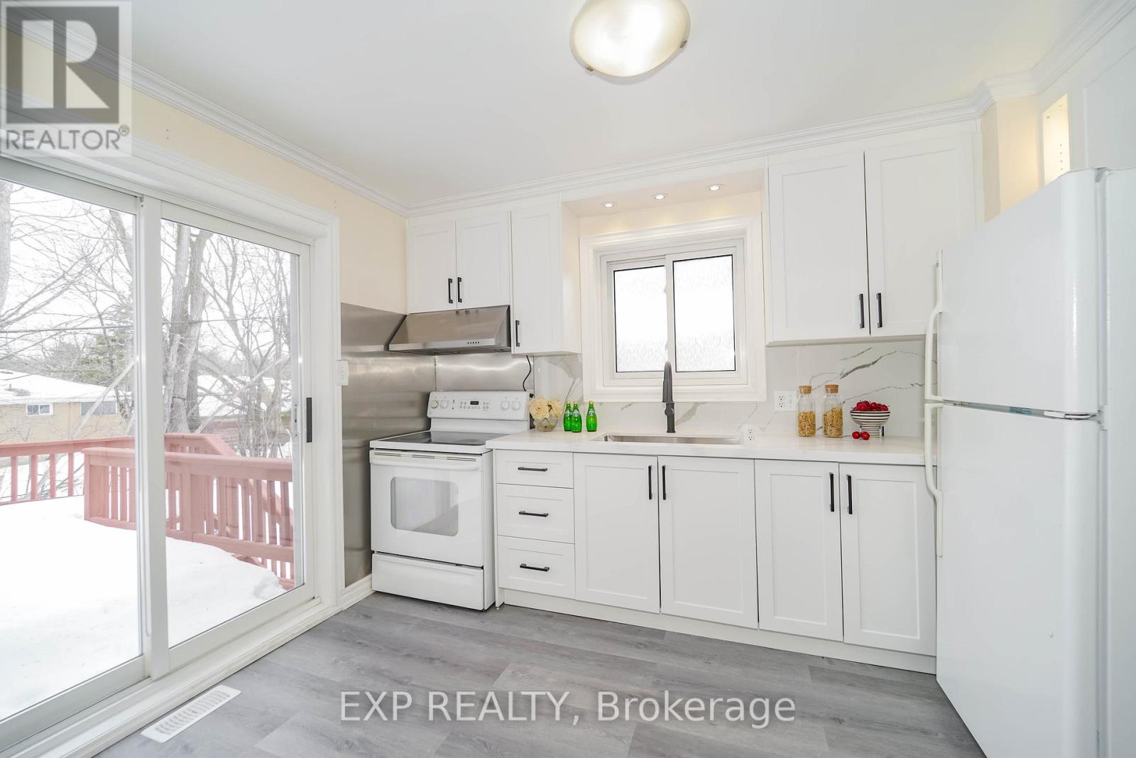 A kitchen with white cabinets and appliances is for sale.