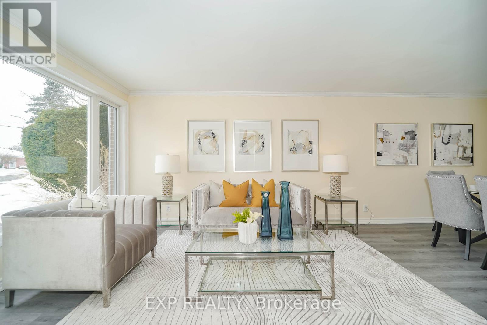 A living room with a glass coffee table and a grey sofa.