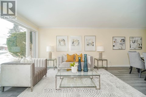 A living room with a glass coffee table and a grey sofa.