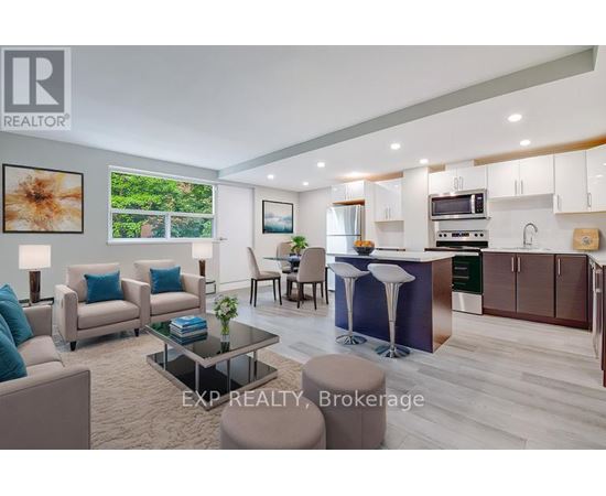 A modern living room with a kitchen area in the background.