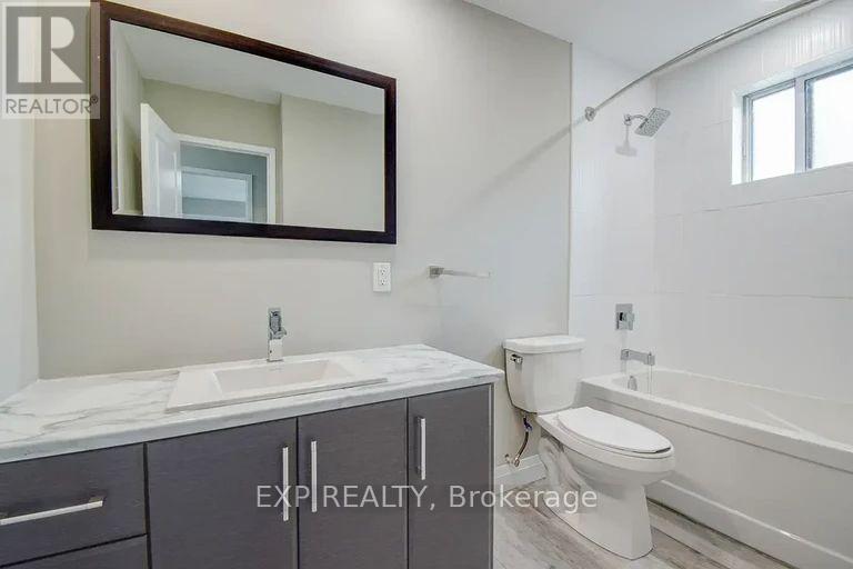 A bathroom with a sink, toilet, and bathtub.