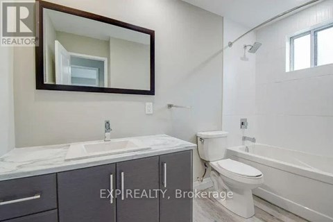 A bathroom with a sink, toilet, and bathtub.