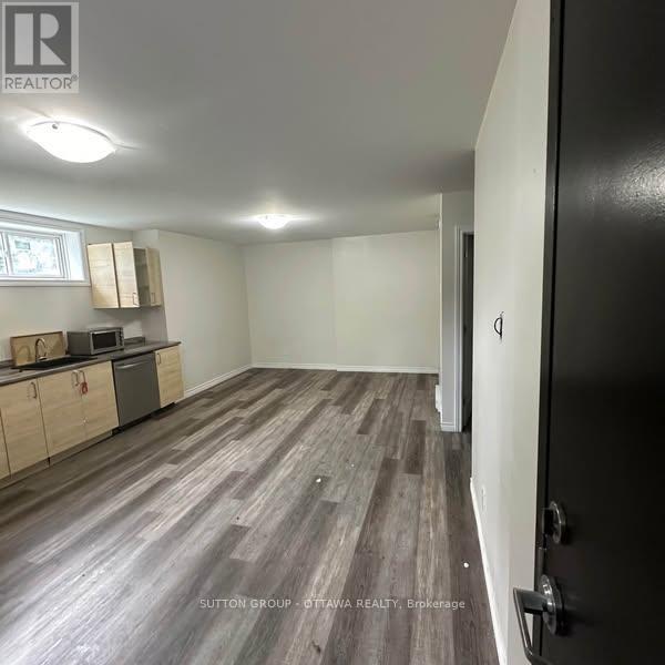 A room with a kitchenette and a refrigerator.