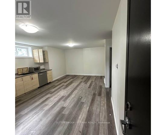 A room with a kitchenette and a refrigerator.