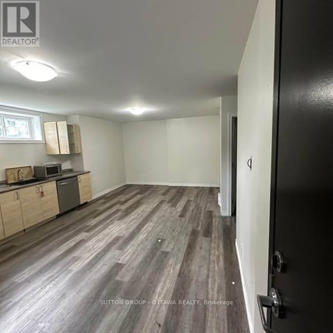 A room with a kitchenette and a refrigerator.