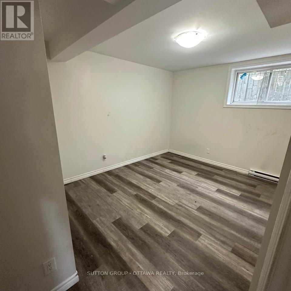 A room with wooden flooring and a window.