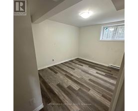 A room with wooden flooring and a window.