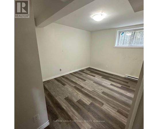 A room with wooden flooring and a window.