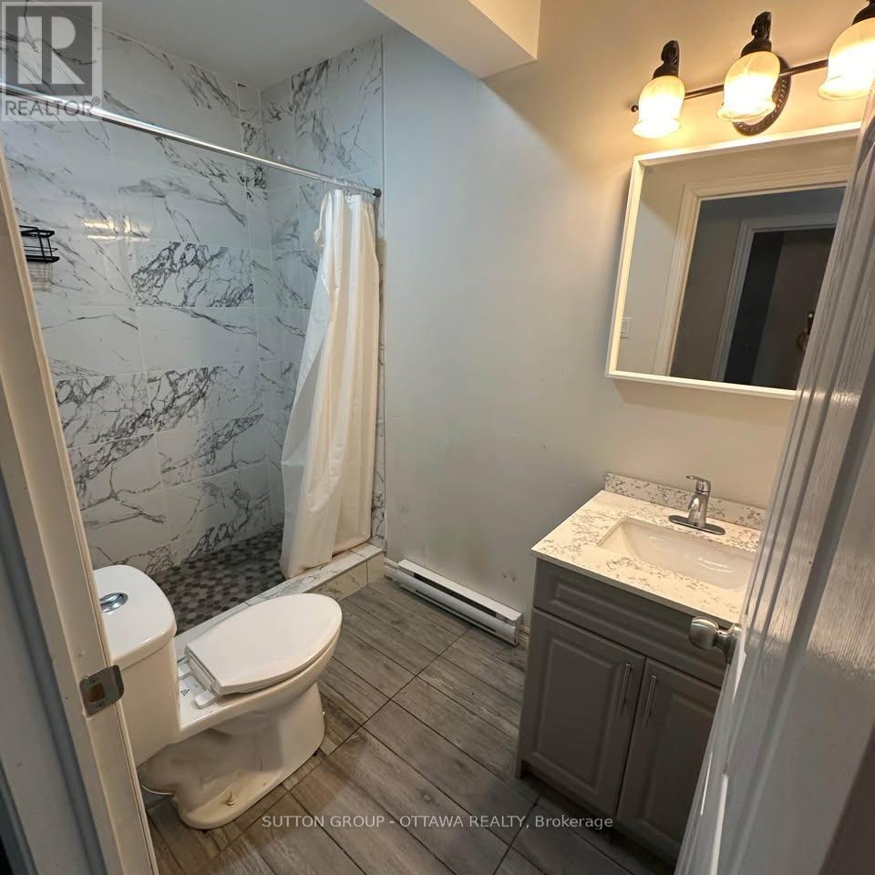 A bathroom with a marble shower and a white toilet.