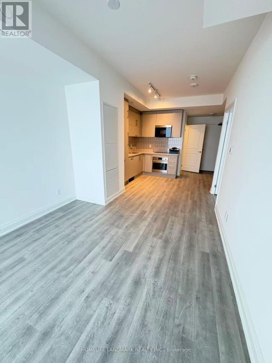 A spacious room with a kitchen area in the background.