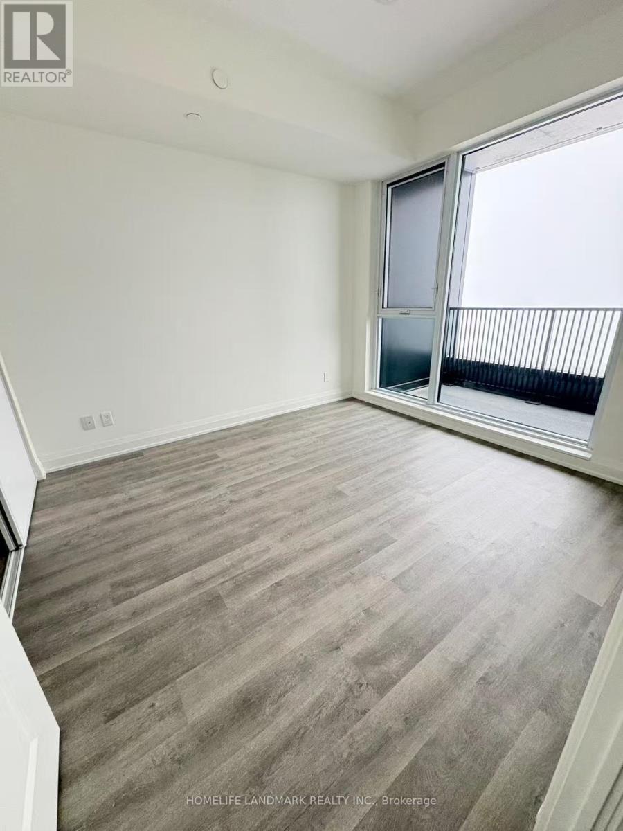 A room with wooden flooring and a sliding glass door.