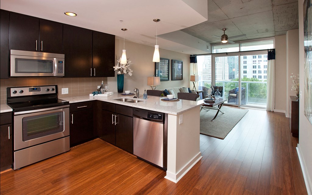 a kitchen and living room with stainless steel appliances