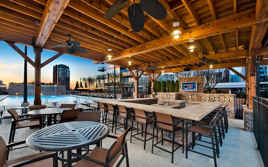 the patio of a restaurant with a bar and a pool