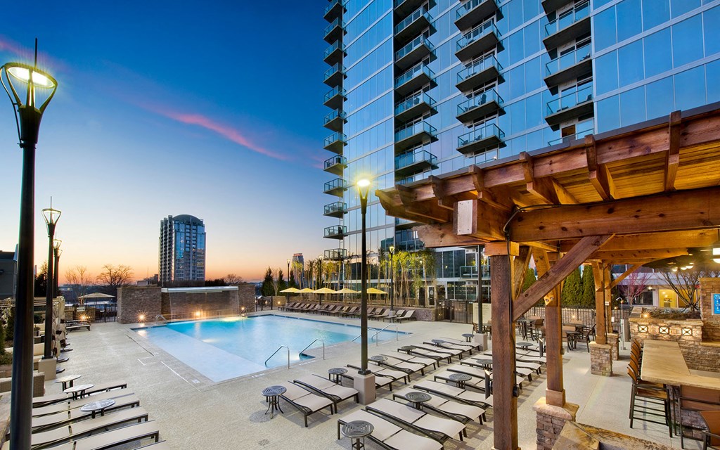 a swimming pool at a hotel with a city in the background