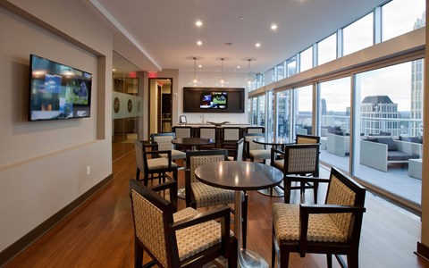 a lounge area with tables and chairs and a television