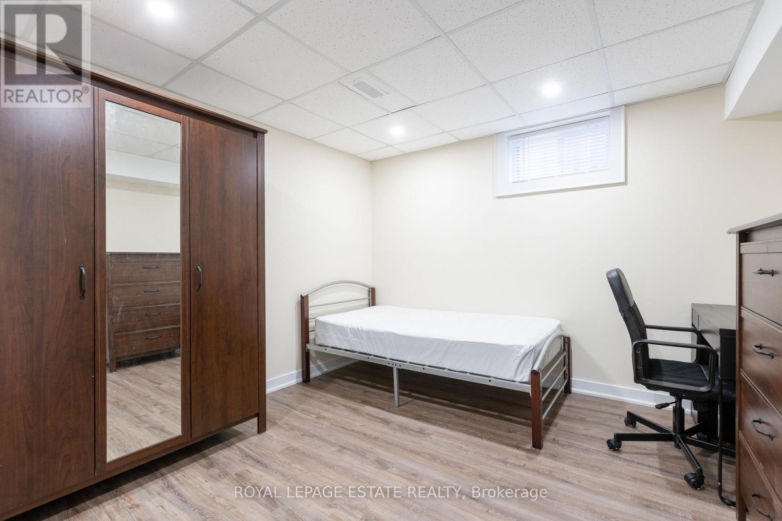 A bedroom with a bed, desk, and chair.