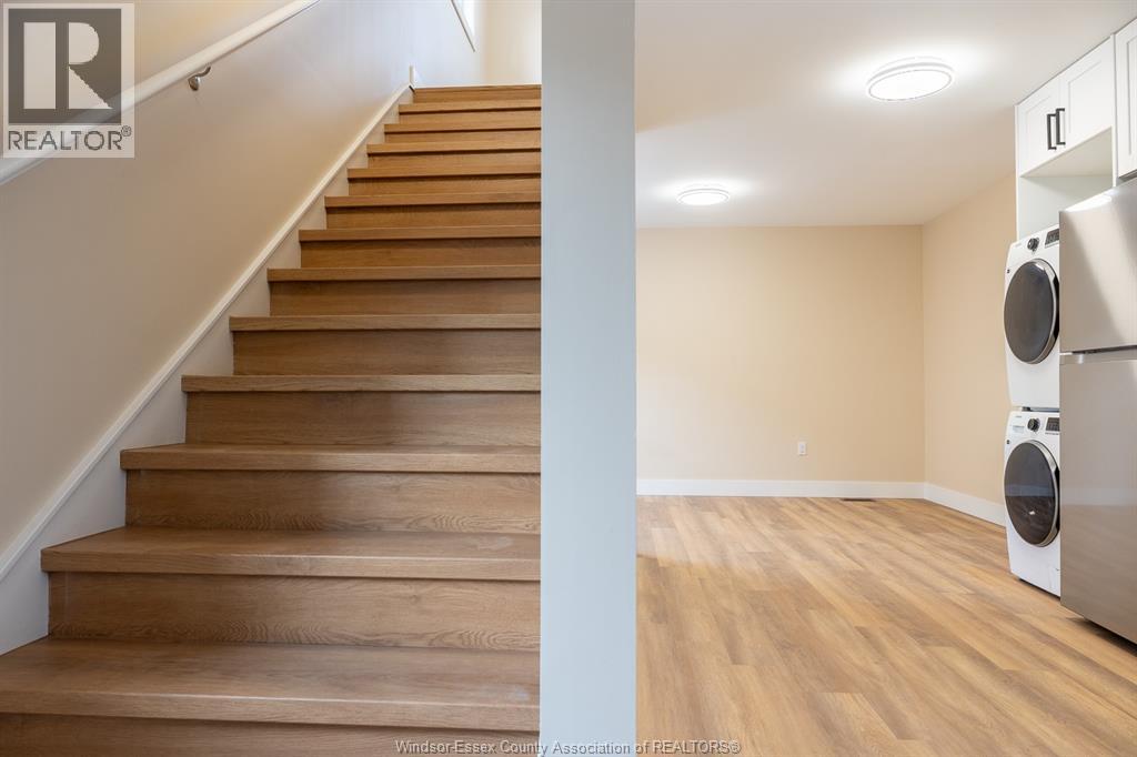 A staircase with wooden steps and a washing machine in the room.